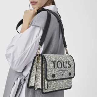 Medium TOUS crossbody handbag from the Audree Kaos Mini collection in black and beige leather-finished polyurethane with Kaos print
