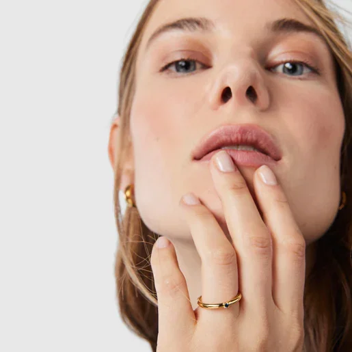 Model with gold ring with small sapphire