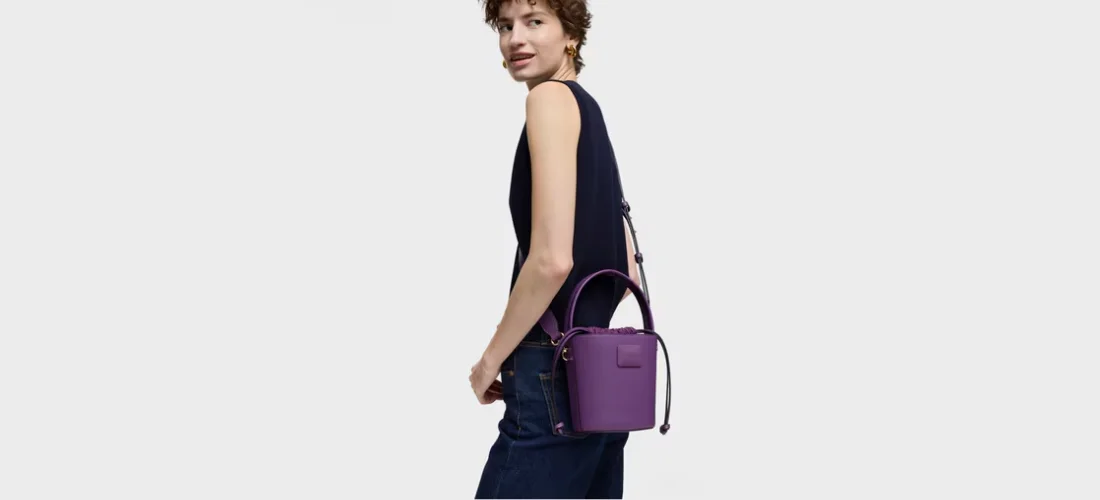 modelo con bolso bombonera morada