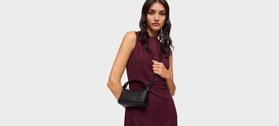 modelo vestida de borgonha com mala preta