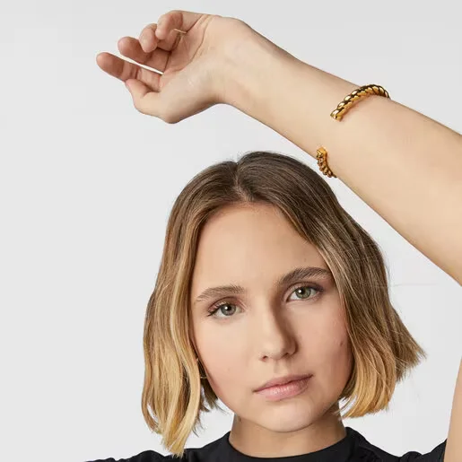 modelo con pulsera bañada en oro rígida