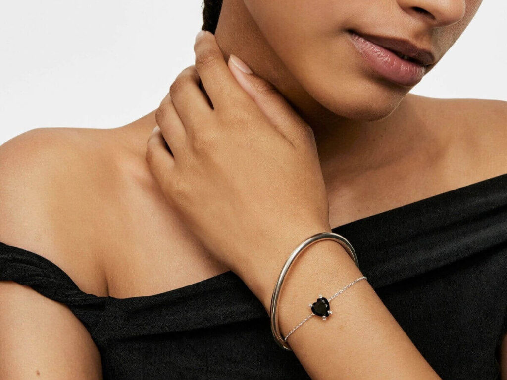 Kobieta z kilkoma srebrnymi bransoletkami na nadgarstku