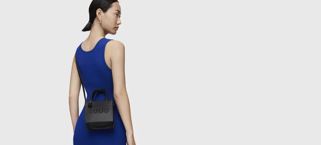 modelo con vestido azul y bolso cruzado negro