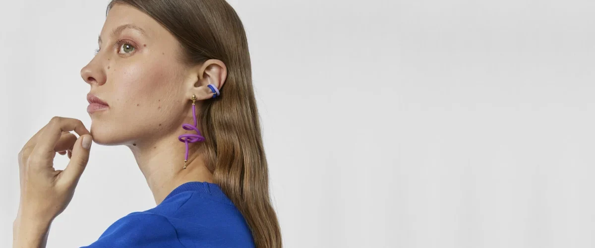 modelo con jersey azul y pendientes de colores