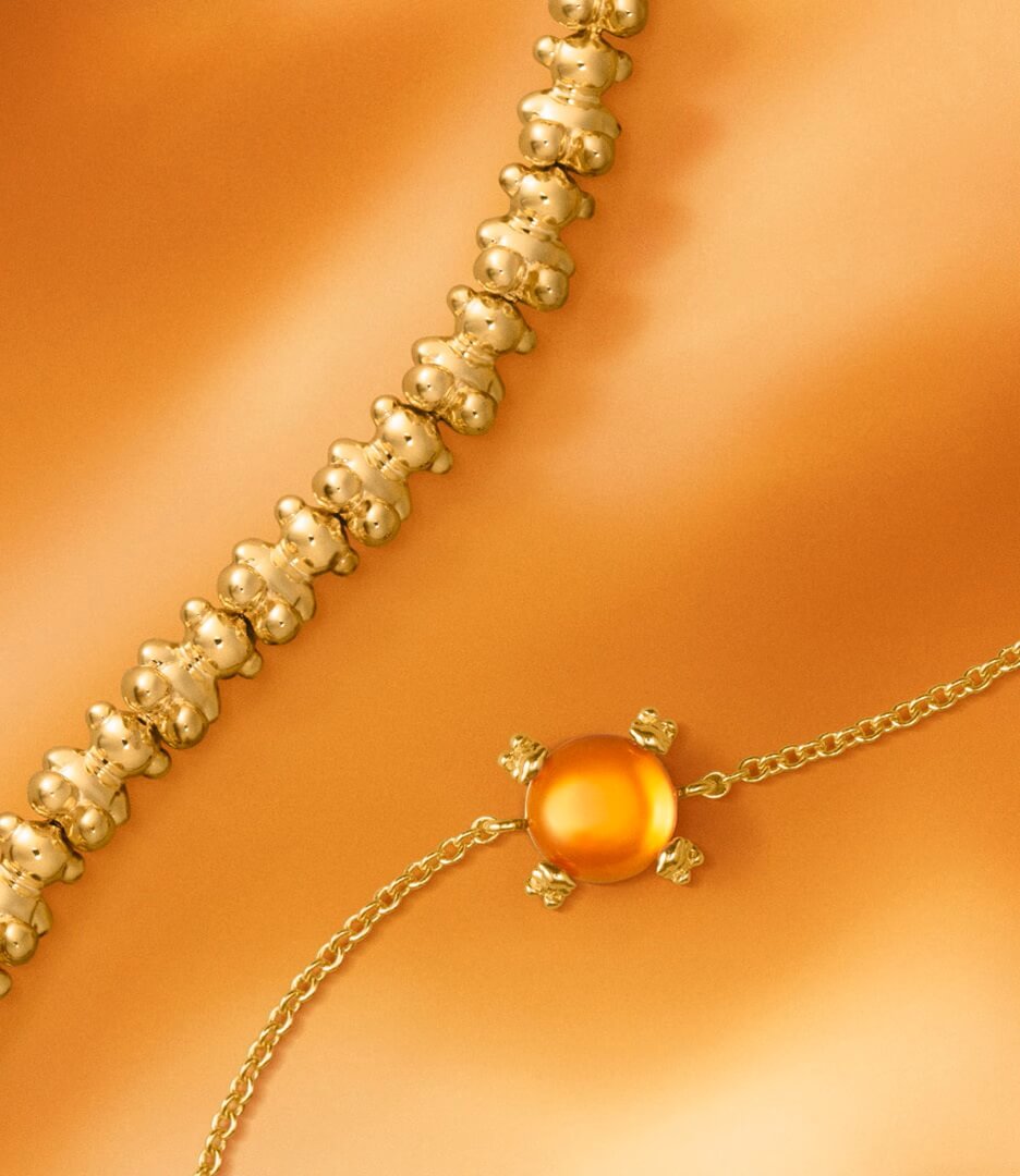 Złote bransoletki TOUS na złotym tle