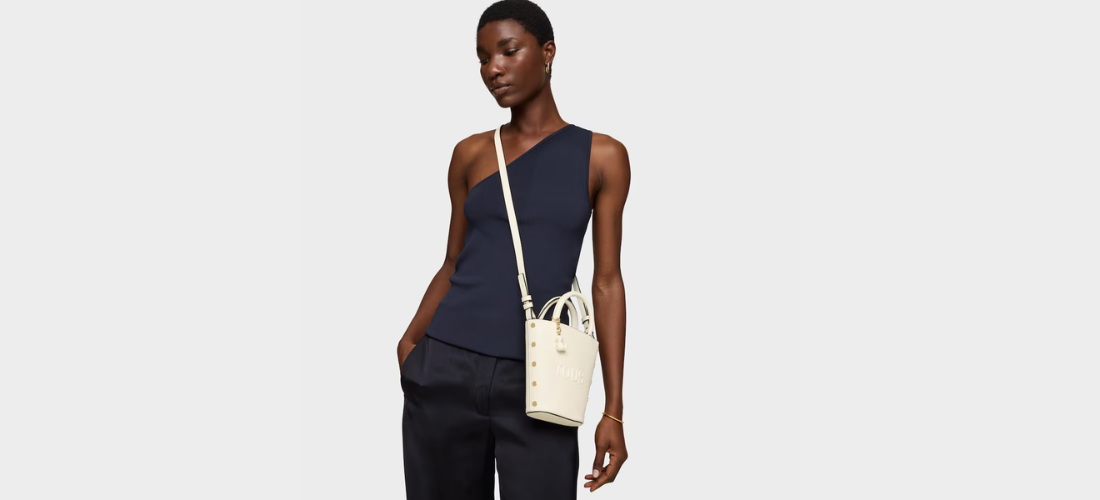 modelo con total look negro y bolso blanco