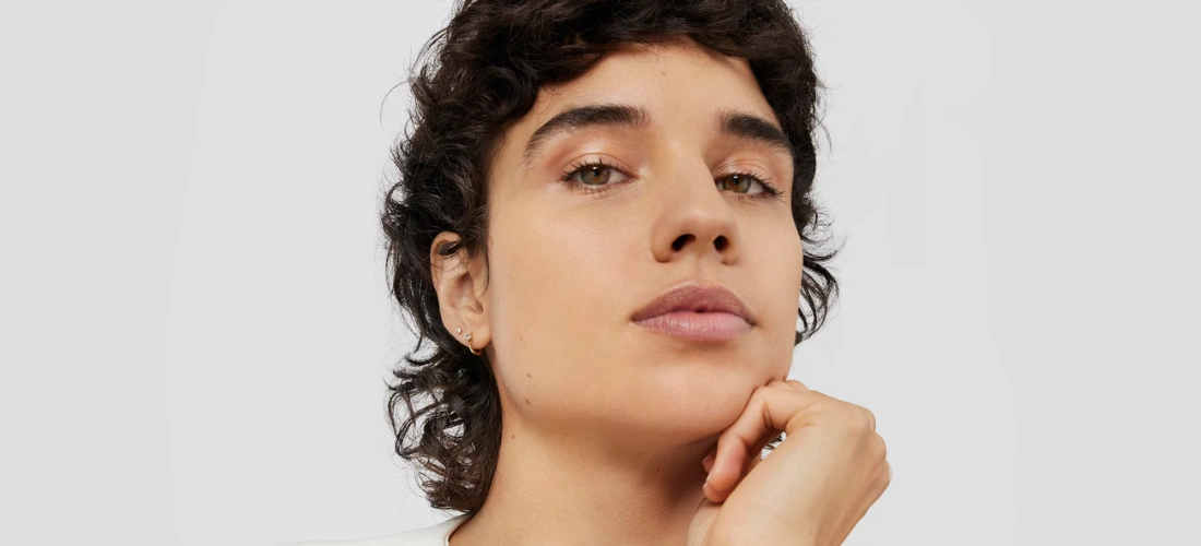 Mulher com piercing de orelha de ouro e diamante