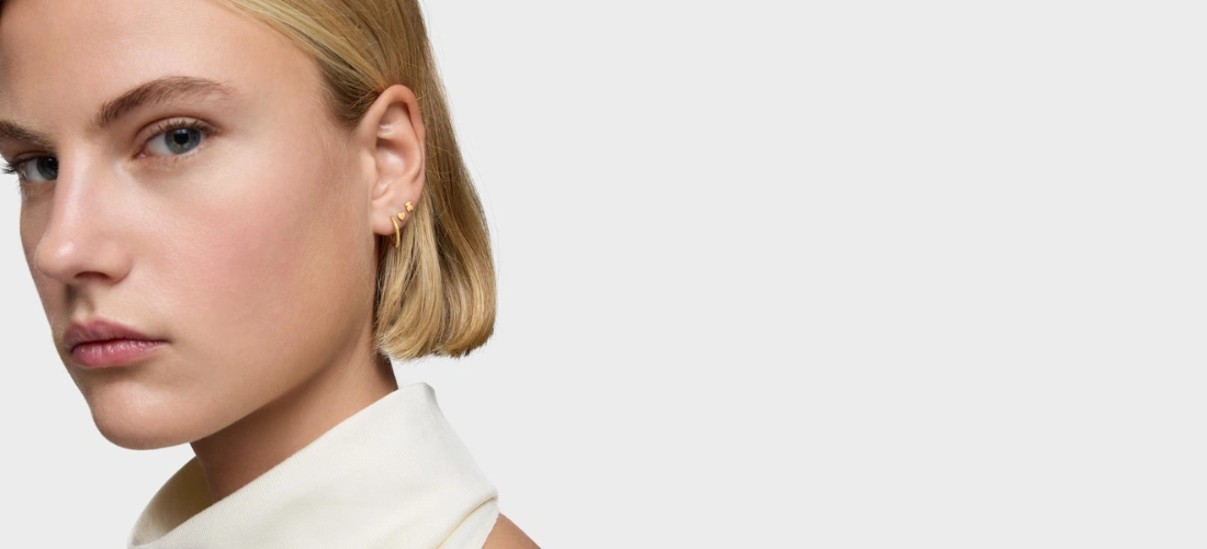 Mulher com piercing de ouro em forma de coração