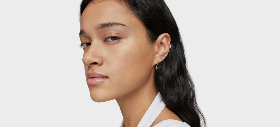 Chica con pendiente corto y largo de plata y gemas de TOUS