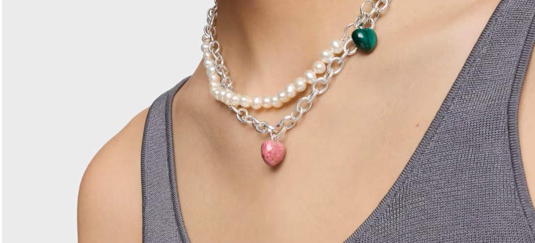 Naszyjniki z rodonitem TOUS na szyi kobiety, jasne tło