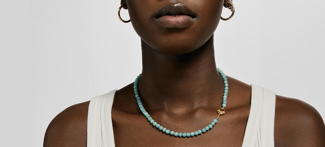 Kobieta z naszyjnikiem TOUS na szyi; naszyjnik z dużymi koralikami amazonitu