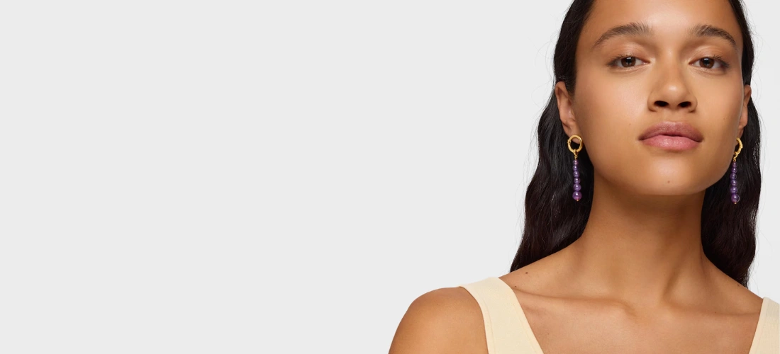menina com brincos compridos com banho de ouro de 18 K sobre prata e ametista