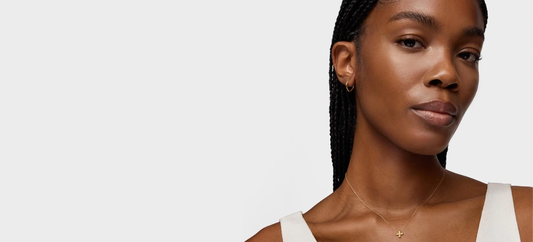 Mulher com colar curto com cruz de ouro e diamantes