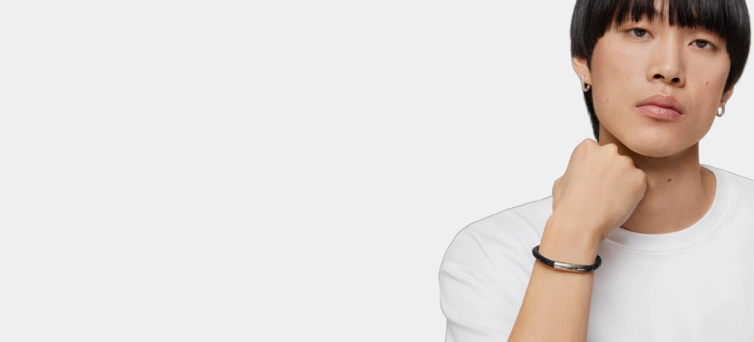 Chico con pulsera en acero y cuero trenzado